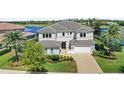 Beautiful two-story home featuring a manicured lawn, lush landscaping, and a brick-paved driveway at 15633 Panther Lake Dr, Winter Garden, FL 34787