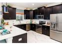 Well-equipped kitchen with stainless steel appliances, dark cabinetry, and sleek countertops at 1673 Moon Valley Dr, Davenport, FL 33896
