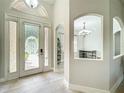 Bright entryway with decorative glass doors and an arched window allowing natural light at 1913 Lazy Oaks Loop, St Cloud, FL 34771