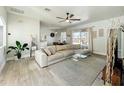 Open-concept living room with wood-look tile and a plush sectional couch at 1913 Lazy Oaks Loop, St Cloud, FL 34771