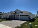 Charming single-story home featuring a stone facade, a paver driveway, and a three-car garage at 2010 Divot Dr, Daytona Beach, FL 32124