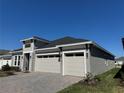 Angle view of home featuring a two-car garage with stone accents and a paver driveway at 2013 Divot Dr, Daytona Beach, FL 32124