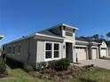 Angle view of home featuring a two-car garage with stone accents, windows, and manicured lawn at 2013 Divot Dr, Daytona Beach, FL 32124