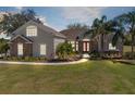 Charming home featuring a well-manicured lawn, mature palm trees, and an inviting front entrance with double doors at 25249 Derby Dr, Sorrento, FL 32776