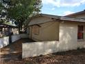 View of backyard showing a retaining wall and boarded up windows at 2652 Ravenall Ave, Orlando, FL 32811