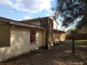 Side view of the home with a concrete block foundation and boarded up windows at 2652 Ravenall Ave, Orlando, FL 32811