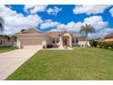 Charming single-story home featuring a well-manicured lawn, beautiful landscaping, and a spacious two-car garage at 2712 Pearl Court, Kissimmee, FL 34743