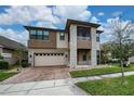 Beautiful two-story home with stone accents, a screened balcony, a paver driveway, and a two car garage at 3018 Jardin St, Kissimmee, FL 34741