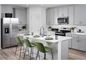 Modern kitchen with stainless steel appliances, an island with seating, and gray cabinets at 309 Castle Dr, Lake Alfred, FL 33850
