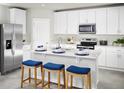 Bright kitchen featuring a large island with seating, stainless steel appliances, and sleek white cabinetry at 313 Castle Dr, Lake Alfred, FL 33850