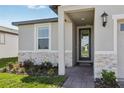 Inviting front porch with a glass door, stone accents, and a well-maintained landscape at 317 Castle Dr, Lake Alfred, FL 33850
