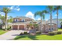 Beautiful two-story home featuring a three car garage, manicured landscaping, and a paver driveway at 3890 Mcguirk Ct, Oviedo, FL 32766