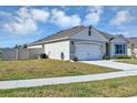 View of home's side and 2-car garage, sidewalk, and a grassy side yard, providing a glimpse of the property's layout at 493 Talisi Loop, St Cloud, FL 34771