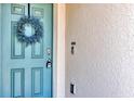 Close-up of a front door with a decorative wreath, showcasing the door's design and entry details at 493 Talisi Loop, St Cloud, FL 34771