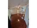 Bright living room with sleek wooden floors, ceiling fan, and an open layout to the kitchen at 5064 Park Central Dr # 1731, Orlando, FL 32839