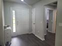 Inviting foyer featuring sleek wood floors, a white front door, and neutral paint colors at 5523 Sw 42Nd Pl, Ocala, FL 34474