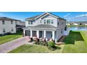 Beautiful two-story house featuring a brick driveway, attached garage, and manicured lawn at 5645 Camilla St, St Cloud, FL 34771