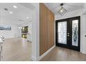 Bright foyer showcasing a modern wood slat accent wall, leading into an open-concept kitchen at 607 Dunblane Dr, Winter Park, FL 32792