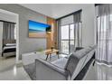 Comfortable living room featuring a gray sofa and a view from the balcony at 6165 Carrier Dr # 3701, Orlando, FL 32819