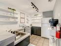 Bright kitchen featuring open shelving, modern appliances, and tiled flooring at 619 Lake Marion Golf Resort, Kissimmee, FL 34759