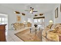 Bright living room with tile flooring, ceiling fan, and decorative shelving at 704 Pinnacle Dr, Haines City, FL 33844