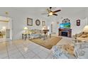 Cozy living room featuring tile floors, ceiling fan, and a fireplace at 704 Pinnacle Dr, Haines City, FL 33844