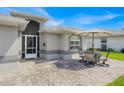 Outdoor patio area with brick pavers and seating for four under an umbrella at 704 Pinnacle Dr, Haines City, FL 33844
