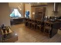 Open-concept kitchen with a large island and chairs, seamlessly flowing into the living area at 7465 Bleecker Ln, Kissimmee, FL 34747