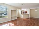 Open-concept living space with wood floors, a closet, and a view into the adjacent kitchen at 9117 Lee Vista Blvd # 603, Orlando, FL 32829