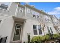 Inviting townhouse showcases light grey siding, white trim, well-kept landscaping, and a green front door at 936 Wild Date Ln, Lake Mary, FL 32746