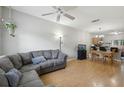 Open-concept living area featuring hardwood floors, a cozy sofa, and a dining area with a chandelier at 104 Wilton Cir, Sanford, FL 32773