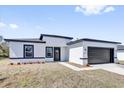 Charming single-story home showcasing black trim and a dark garage door, perfect for modern living at 13584 Sw 43Rd Cir, Ocala, FL 34473