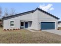 Beautiful single-story home with modern architecture, featuring a blue garage door and gray stucco at 13594 Sw 40 Cir, Ocala, FL 34473