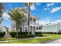 Attractive two-story home with a welcoming double porch, complemented by lush landscaping at 1552 Fairview Cir, Reunion, FL 34747