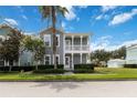 Beautiful two-story home with double porch and manicured lawn, set against a backdrop of blue skies at 1552 Fairview Cir, Reunion, FL 34747