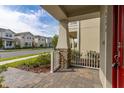 Covered front porch showcasing stone accents, pavers, and a view of the landscaped street at 16294 Honey Harvest St, Winter Garden, FL 34787