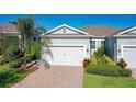 Home with manicured lawn and colorful landscaping, showcasing its well-maintained curb appeal under a clear blue sky at 1830 Estuary Ln, Kissimmee, FL 34747