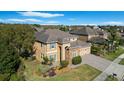 Aerial view showing beautiful two-story home, landscaping, neutral paint, blue shutters, and a paved driveway in a suburban neighborhood at 2015 Sandy Garden Ln, Winter Garden, FL 34787