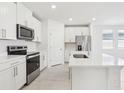 Bright kitchen featuring an island with a sink, stainless appliances and white cabinets at 2098 Rosewood Dr, Bartow, FL 33830