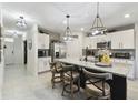 Modern kitchen features a large center island with seating, stainless steel appliances, and elegant pendant lighting at 211 Lazio Cir, Debary, FL 32713