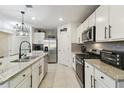Well-equipped kitchen with stainless steel appliances, granite countertops, white cabinetry and tile flooring at 211 Lazio Cir, Debary, FL 32713