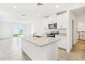 Bright open-concept kitchen features an island, granite countertops, white cabinetry and stainless steel appliances at 2507 Linda Knoll Ln, Bartow, FL 33830