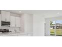 Bright kitchen featuring stainless steel appliances, white cabinets, and a view to the back yard at 2515 Linda Knoll Ln, Bartow, FL 33830