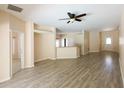 Open-concept living room with wood-look floors and view of the kitchen counter at 2788 Roccella Ct, Kissimmee, FL 34747