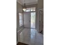 Bright foyer featuring tiled flooring, a decorative light fixture, and a window with blinds for natural light at 3125 Timucua Cir, Orlando, FL 32837
