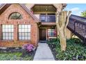 Charming townhome entrance with brick facade, colorful flower garden, and stairway to upper level at 366 Waterside Dr # 102, Altamonte Springs, FL 32701