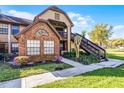 Inviting townhouse exterior showing a landscaped front yard, brick accents, and convenient stair access at 366 Waterside Dr # 102, Altamonte Springs, FL 32701