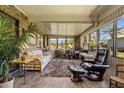 Bright sunroom with brick wall, tile floors, multiple windows, and comfortable seating at 398 Troon Ct, Winter Haven, FL 33884