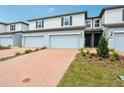 Modern townhomes showcasing brick driveways leading to attached garages and well-maintained landscaping at 4337 Switchgrass Ln, St Cloud, FL 34772