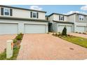 Newly built townhomes feature brick driveways, attached garages, and beautifully manicured front yards at 4337 Switchgrass Ln, St Cloud, FL 34772